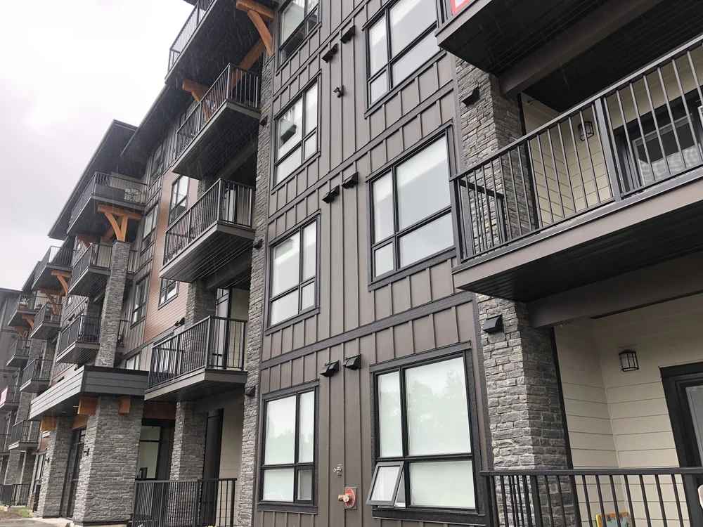 Silver Pearl frames the balcony bays and entry of an apartment block in tight split courses.