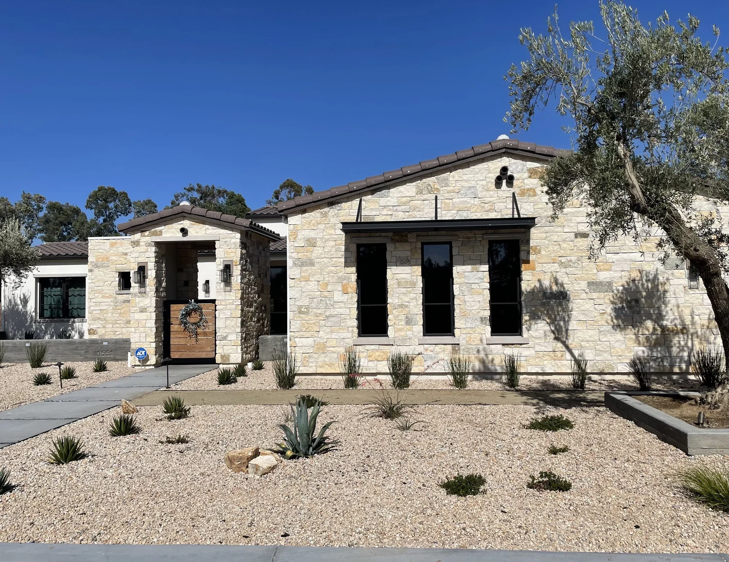 Oceanside Estate ashlar veneer and honed Indiana Limestone sills and lintels across a home facade and entry.