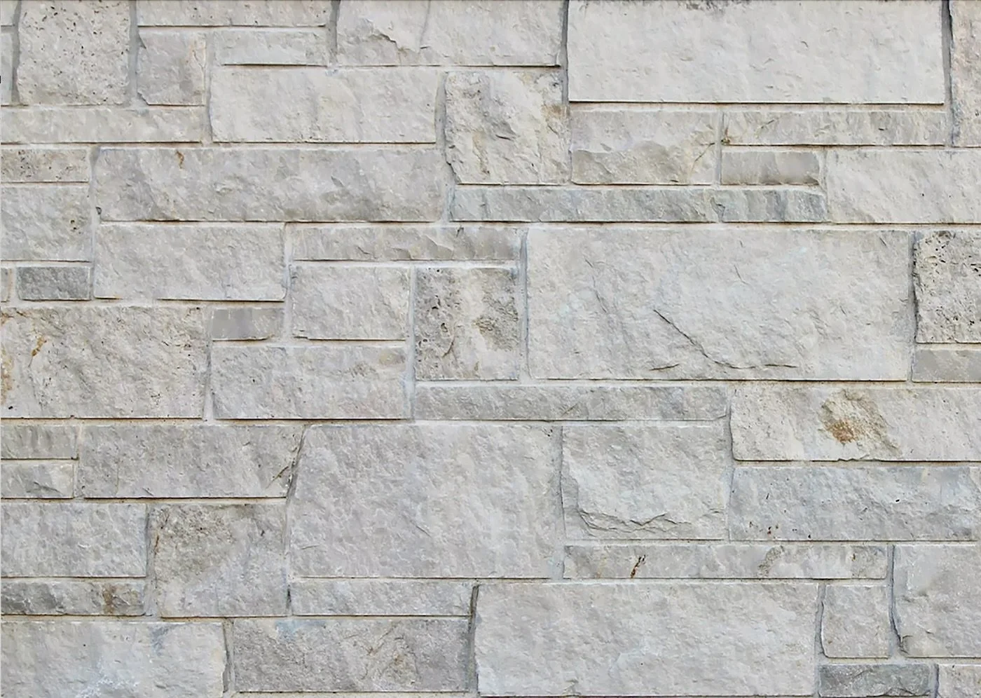 Norway ashlar in mixed course heights, near white with tight joints and long low units.