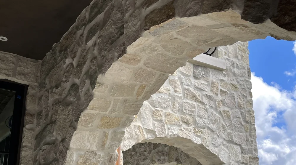 Tuscany field veneer and Indiana Limestone custom pieces on a facade.
