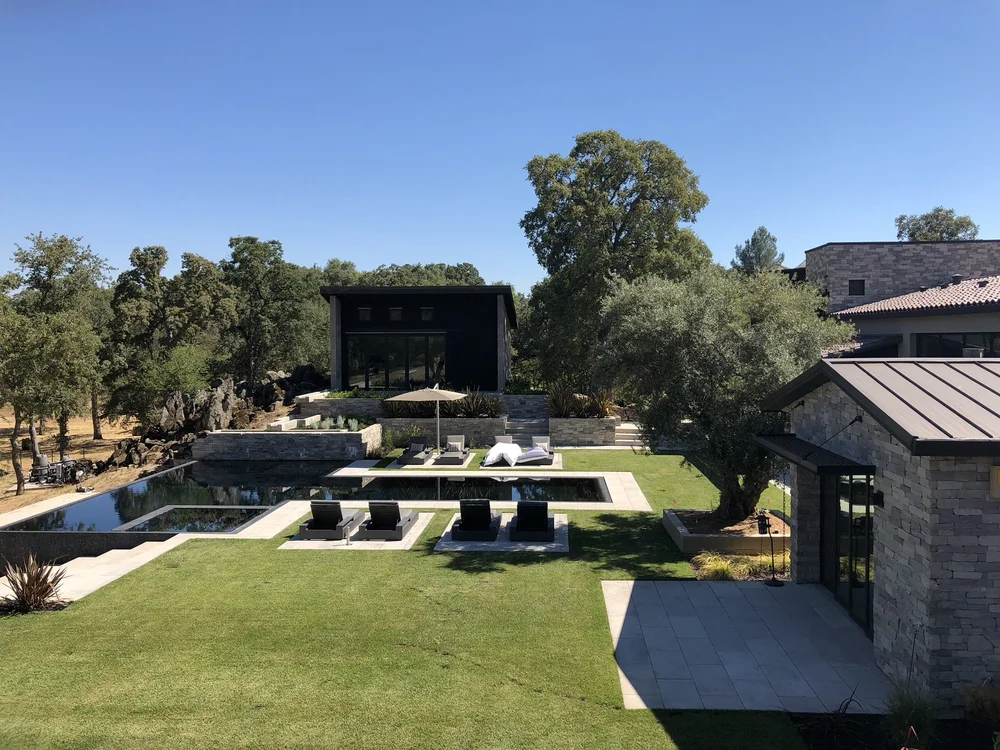 Seen from above, the pool and lawn run the length of the property between Mayville clad wings.