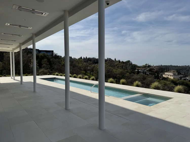 White honed paving and bevel-edge coping anchoring a pool terrace.