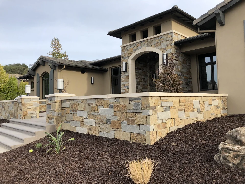 Monterey Estate ashlar veneer in split and natural faces with dry-stack joints wrapping a facade, entry, and wall.