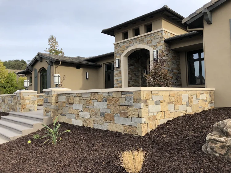 Monterey Estate ashlar veneer in split and natural faces with dry-stack joints wrapping a facade, entry, and wall.
