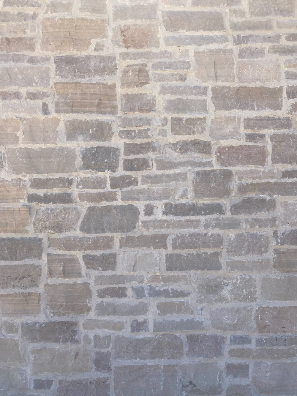 Mayville ledge set with mortar worked out over the stone edges, warm gray and heavily jointed.