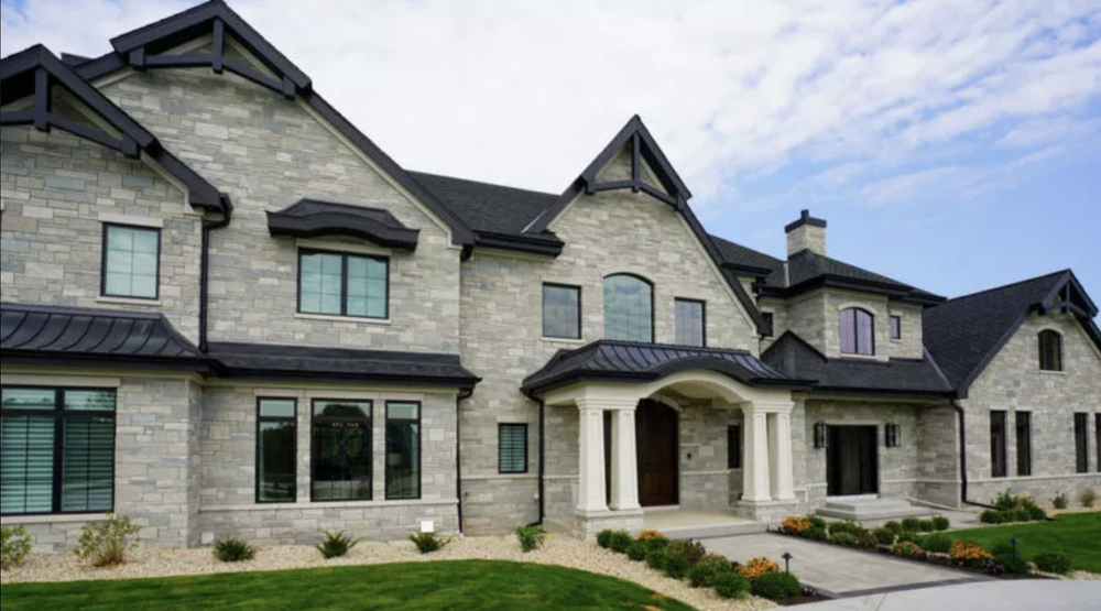 Fond du Lac ashlar covers the front of a large gabled house, dark trim framing every opening.