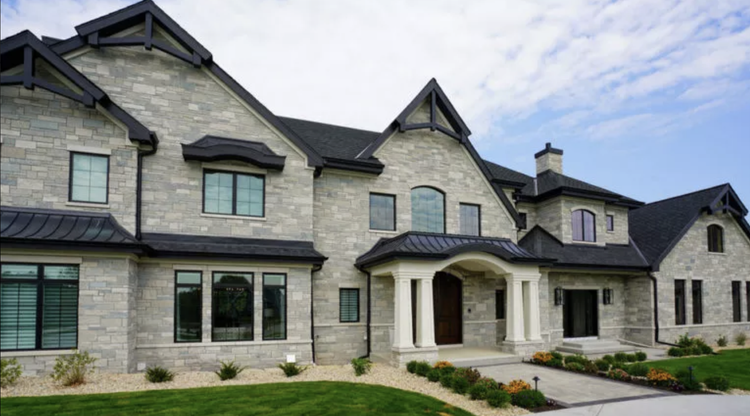 Fond du Lac ashlar covers the front of a large gabled house, dark trim framing every opening.