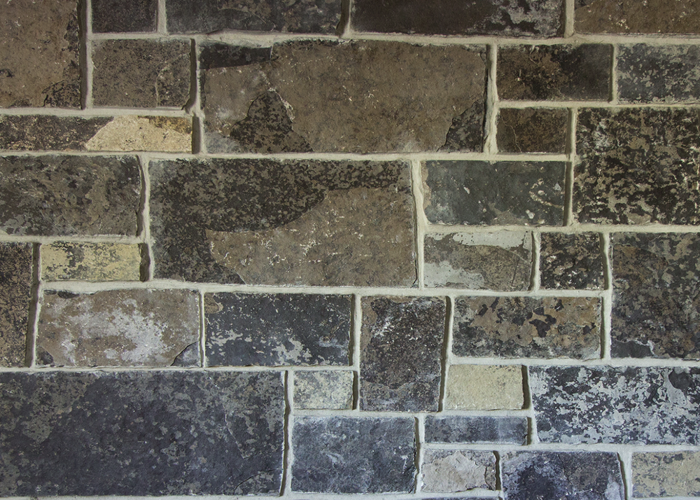 Graphite castle veneer in split face, squared blocks of charcoal, rust and cream in mixed sizes.