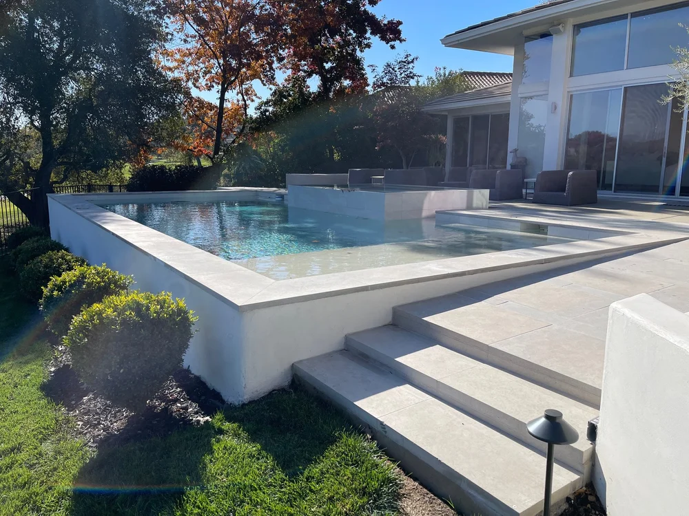 Indiana Limestone laid as wall caps and Indiana Limestone dimensional pavers in a honed finish on a patio.