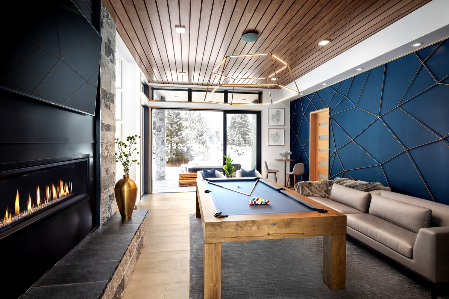 Charcoal split-face veneer surrounds a linear gas fireplace in a game room under a slatted wood ceiling.