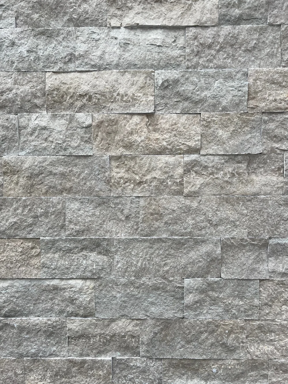 Avalon coursed veneer shown up close, split faces in cool gray with dry-stack joints.