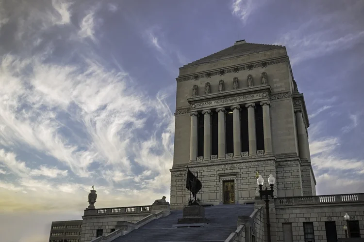 Indiana Limestone laid as panel veneer in honed face and Indiana Limestone sills, lintels, jambs, keystones, column caps, wall caps, custom pieces, balustrades, railings, and corbels on a facade.