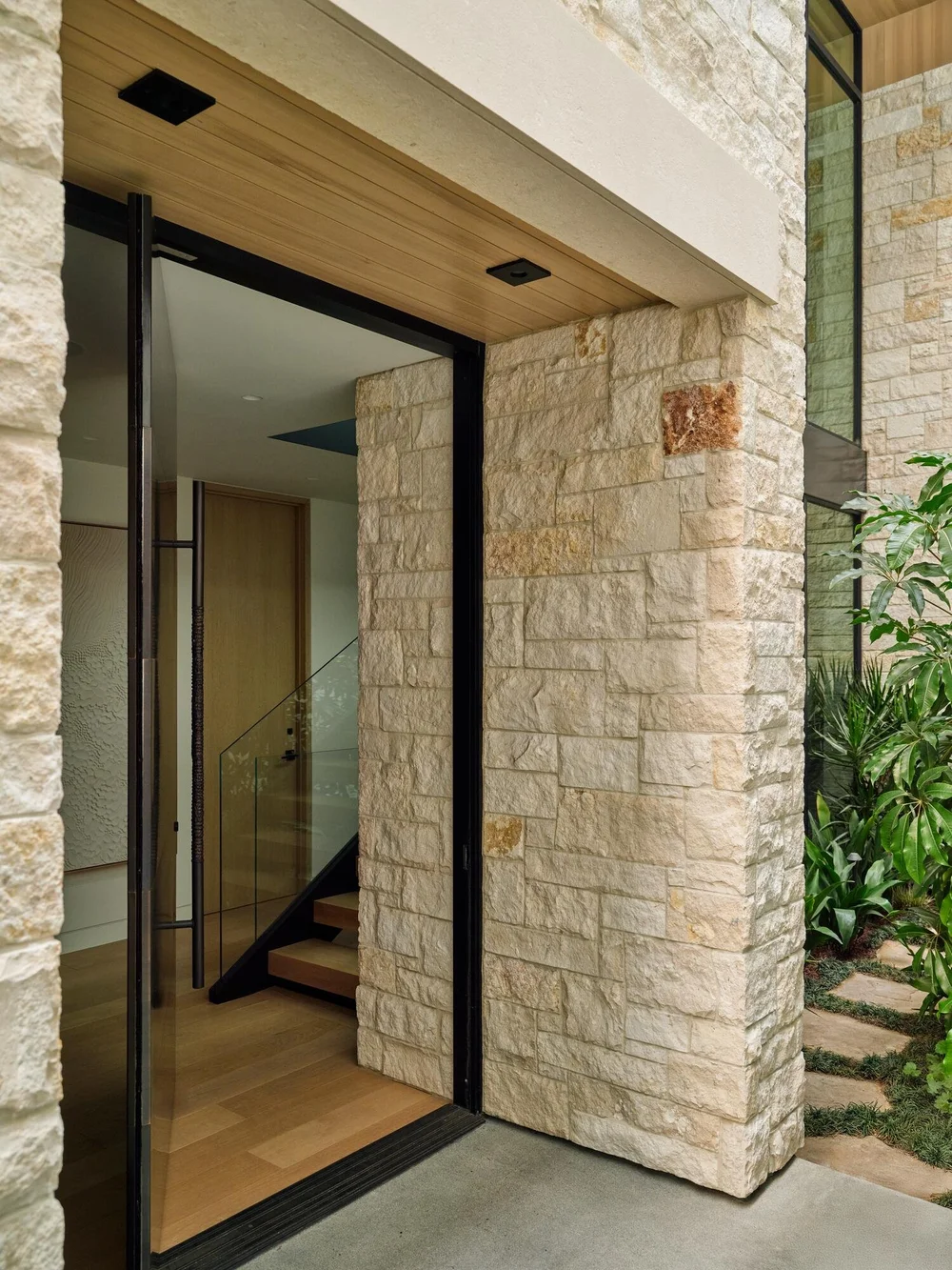 Sea Fossil ashlar veneer with flush joints and honed Cream lintels framing an interior entry.