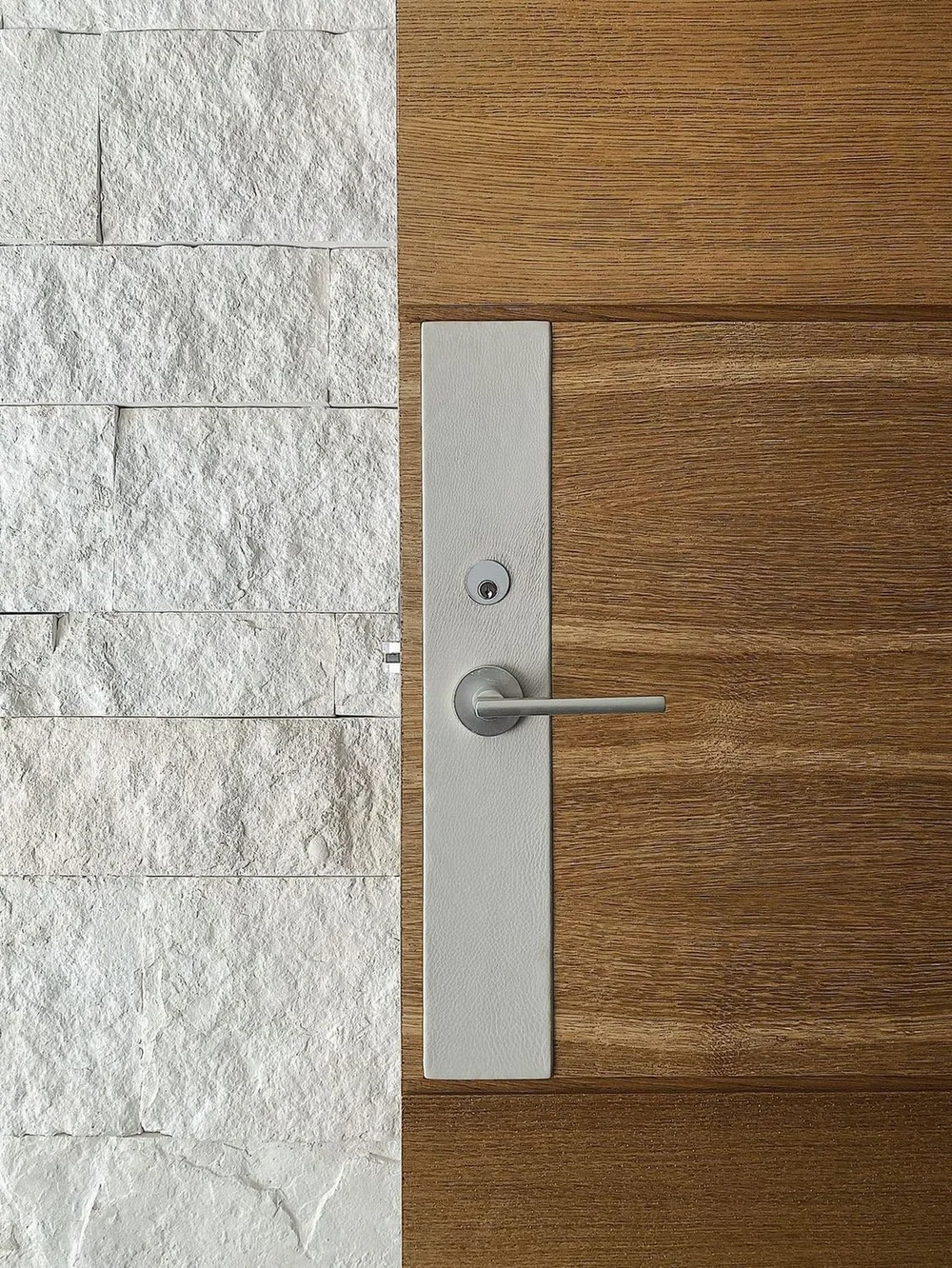 White coursed veneer with split face and dry-stack joints in an interior living space.