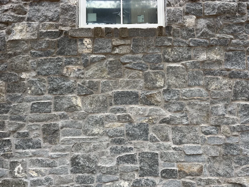 Rocky Mountain Granite carries up to a white window head, its blocks set in irregular courses.