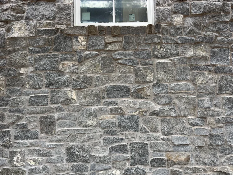 Rocky Mountain Granite carries up to a white window head, its blocks set in irregular courses.