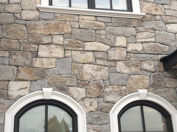 Rhyolite field veneer in natural and split faces across a facade.