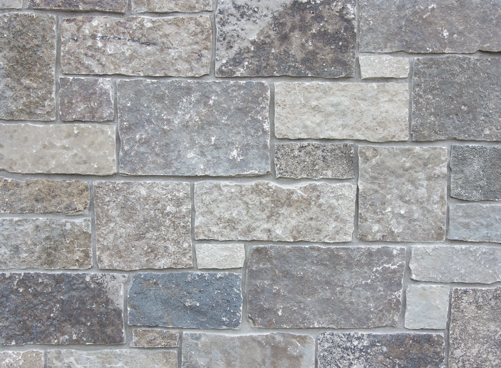 Fond du Lac castle veneer in split face, squared blocks of mixed gray and buff fitted with tight joints.