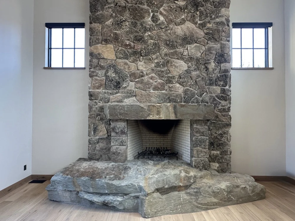 A wide view of the Montana Moss mosaic fireplace wall in split face.