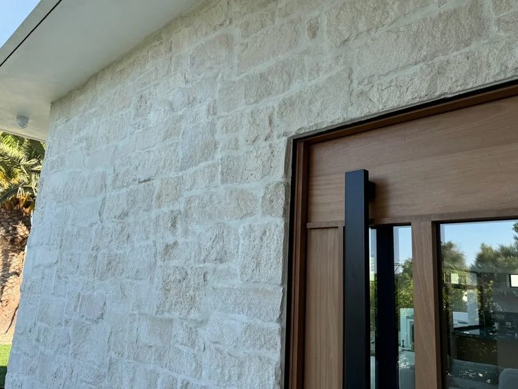 Cottonwood veneer in overgrouted split-face courses at a home entry.