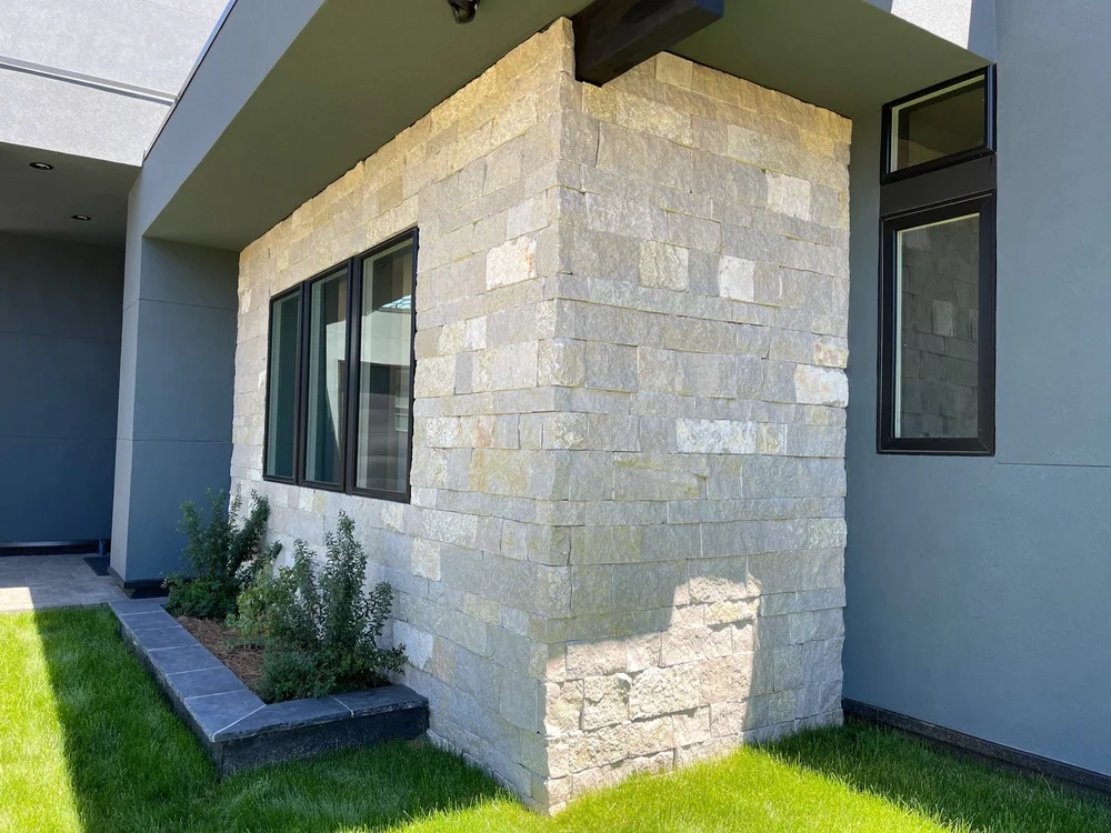 Avalon veneer wraps a projecting corner between stucco walls and lawn.