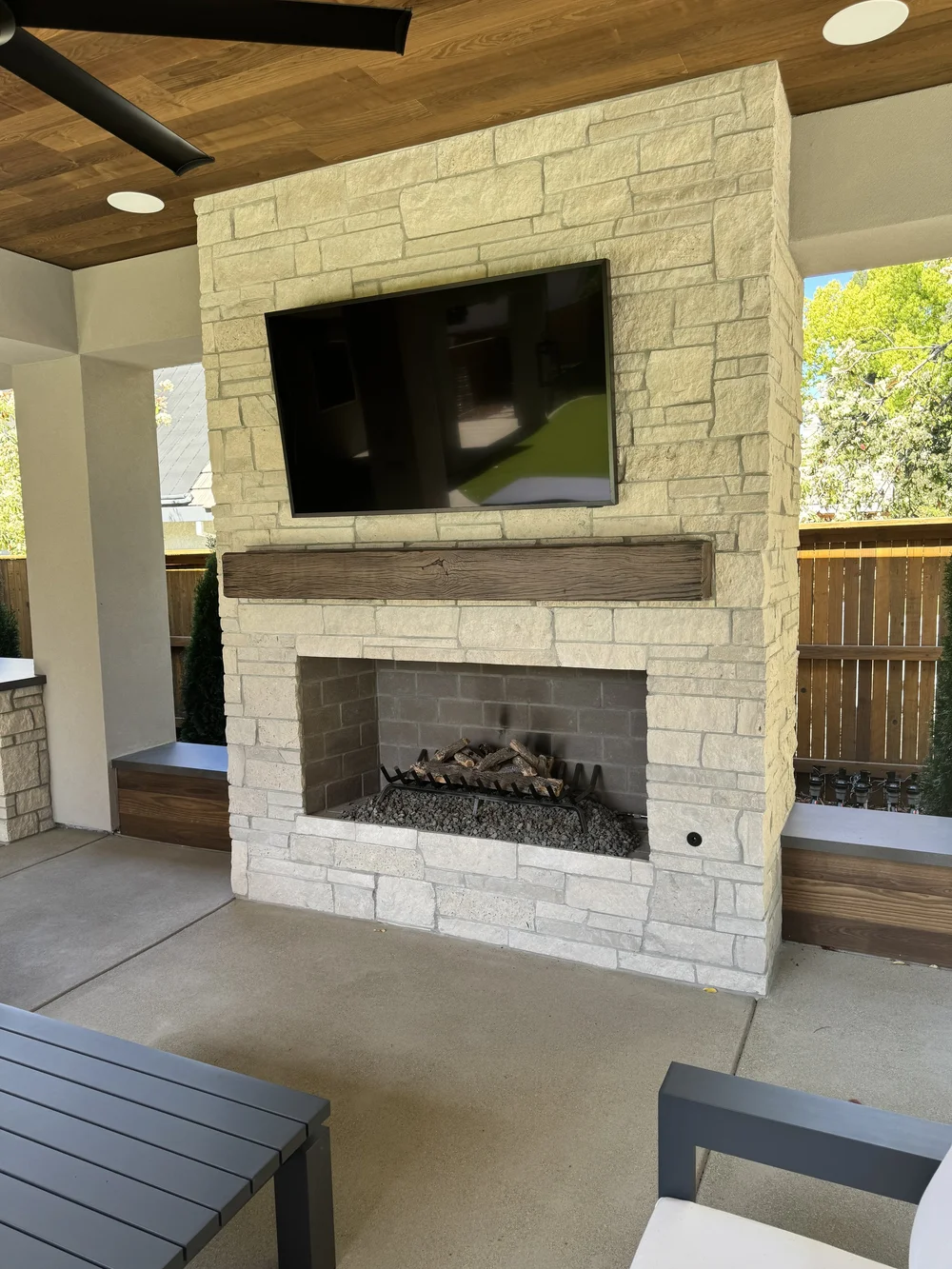 A Norway fireplace runs floor to ceiling behind a timber mantel and a mounted screen.