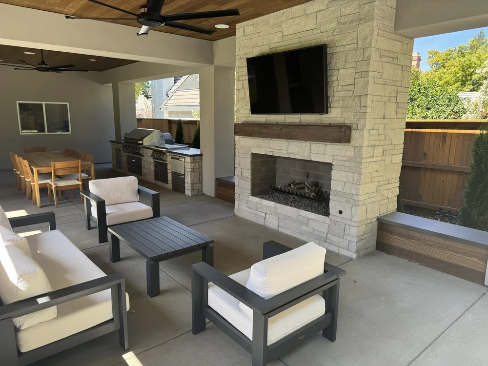 Seen from the seating side, the Norway fireplace stands against the fence line with the kitchen beyond.