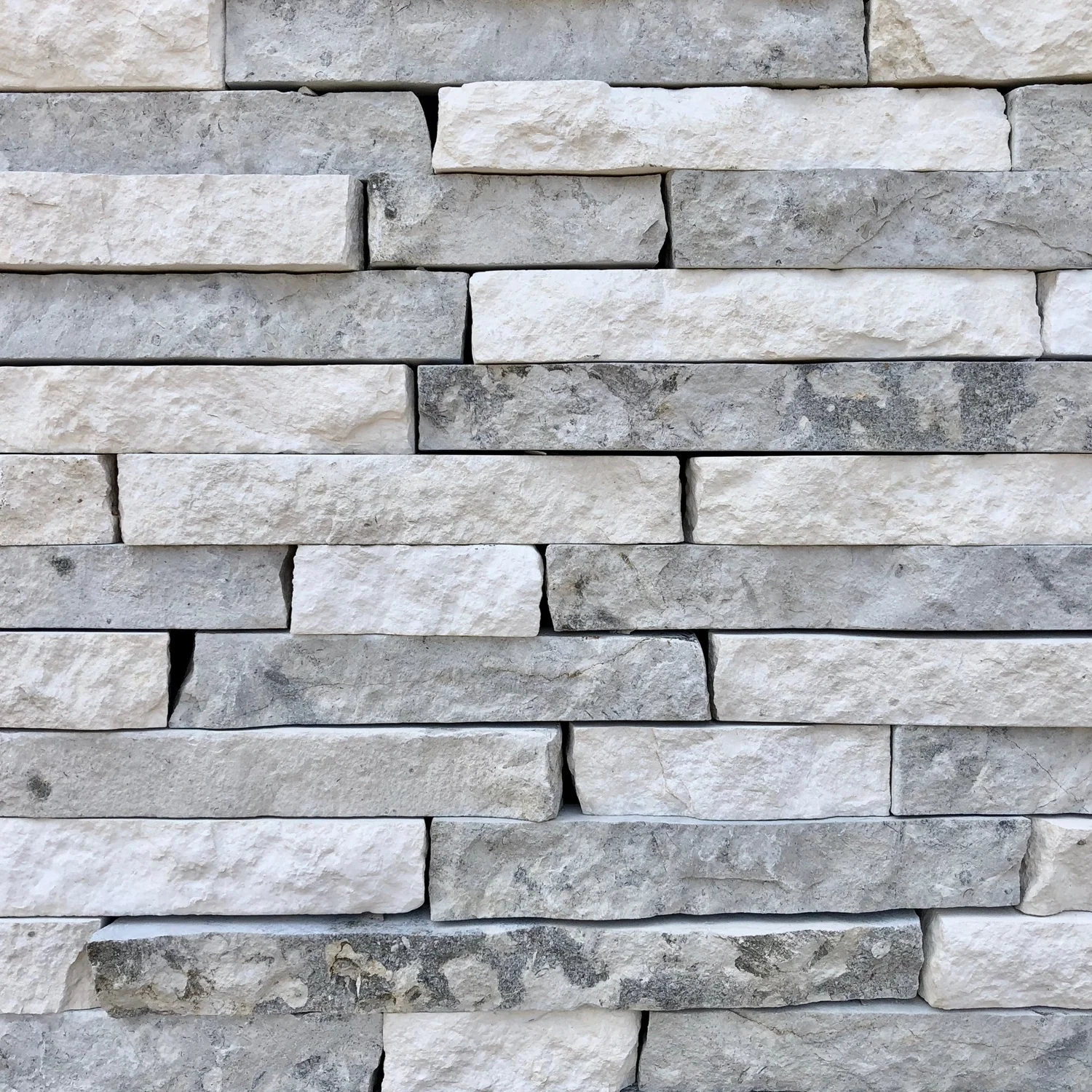 Vail ledge stacked tight in thin courses, chalk white units running through cool gray.