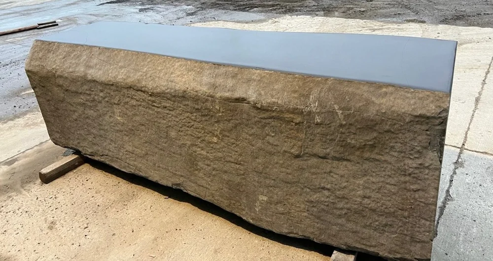 Custom Black Mountain wine table with a polished black top over natural, split, and hand-chiseled stone sides.