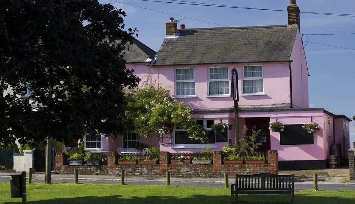 The pink Rosebud pub, seen from across the green