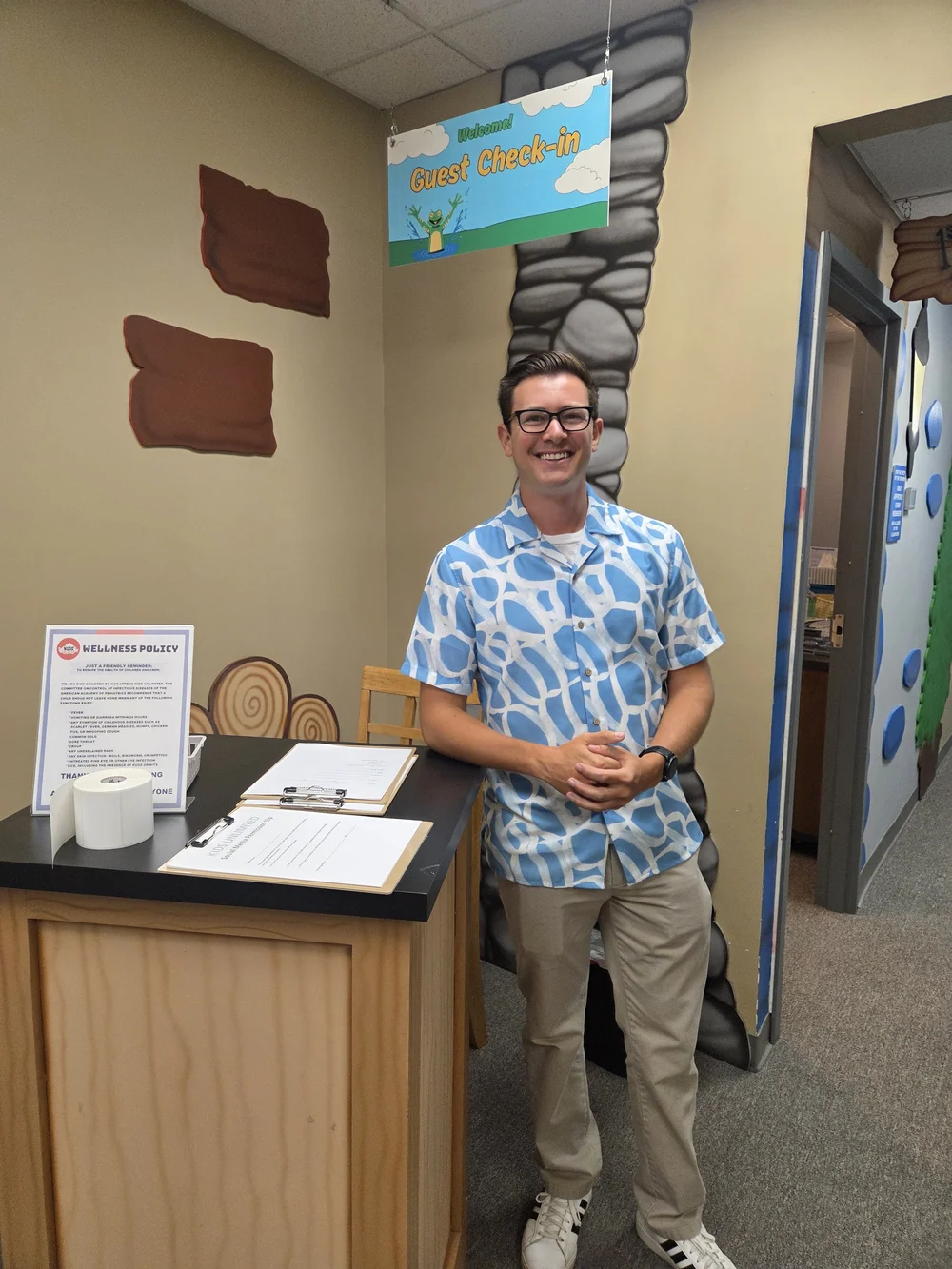 Welcome team member at the Kids Unlimited guest check-in desk