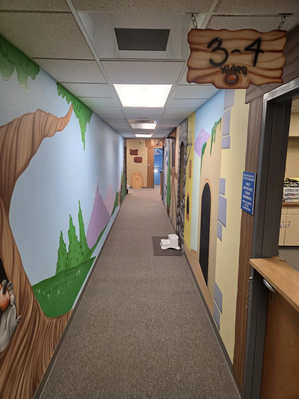 Colorful tree and castle murals in the upstairs Kids Unlimited hallway