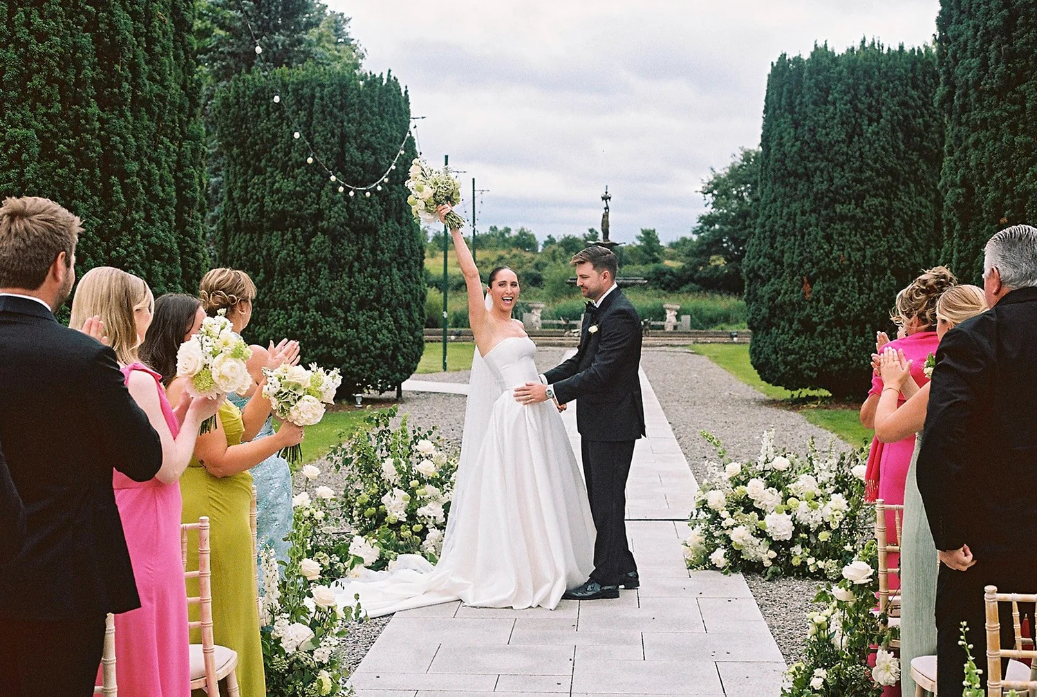 Couple celebrating at the end of an outdoor aisle at The K Club in Kildare, photographed on film