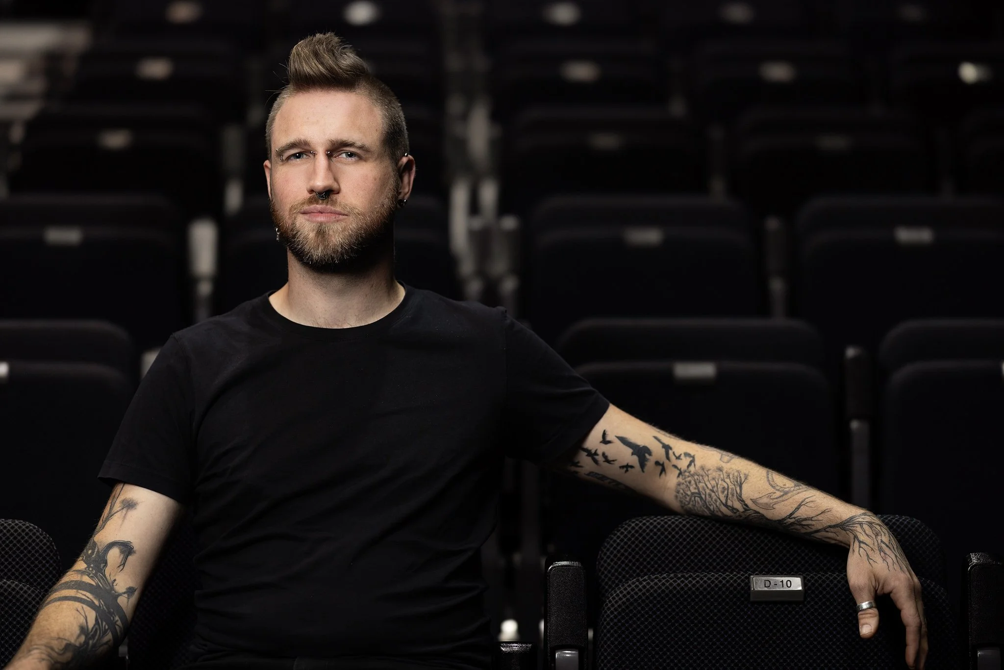 Nick Hedger seated among theatre chairs