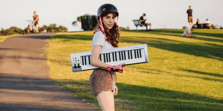 From Little Things promotional photograph, a performer with a keyboard in a sunlit park