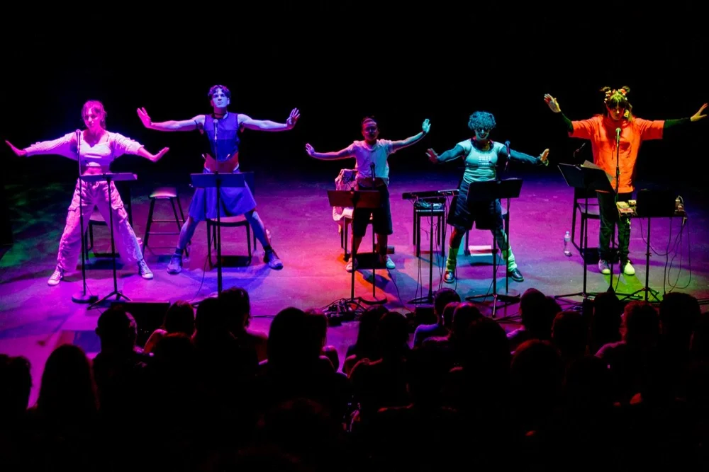 The ensemble of A Transgender Woman on the Internet, Crying performing together in front of an audience