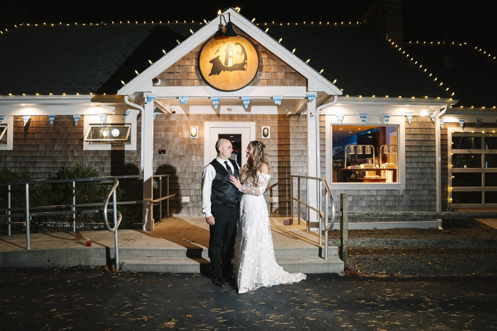 A couple outside the lit Naukabout Taproom