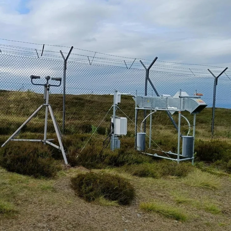 Monitoring equipment in front of a fence. 