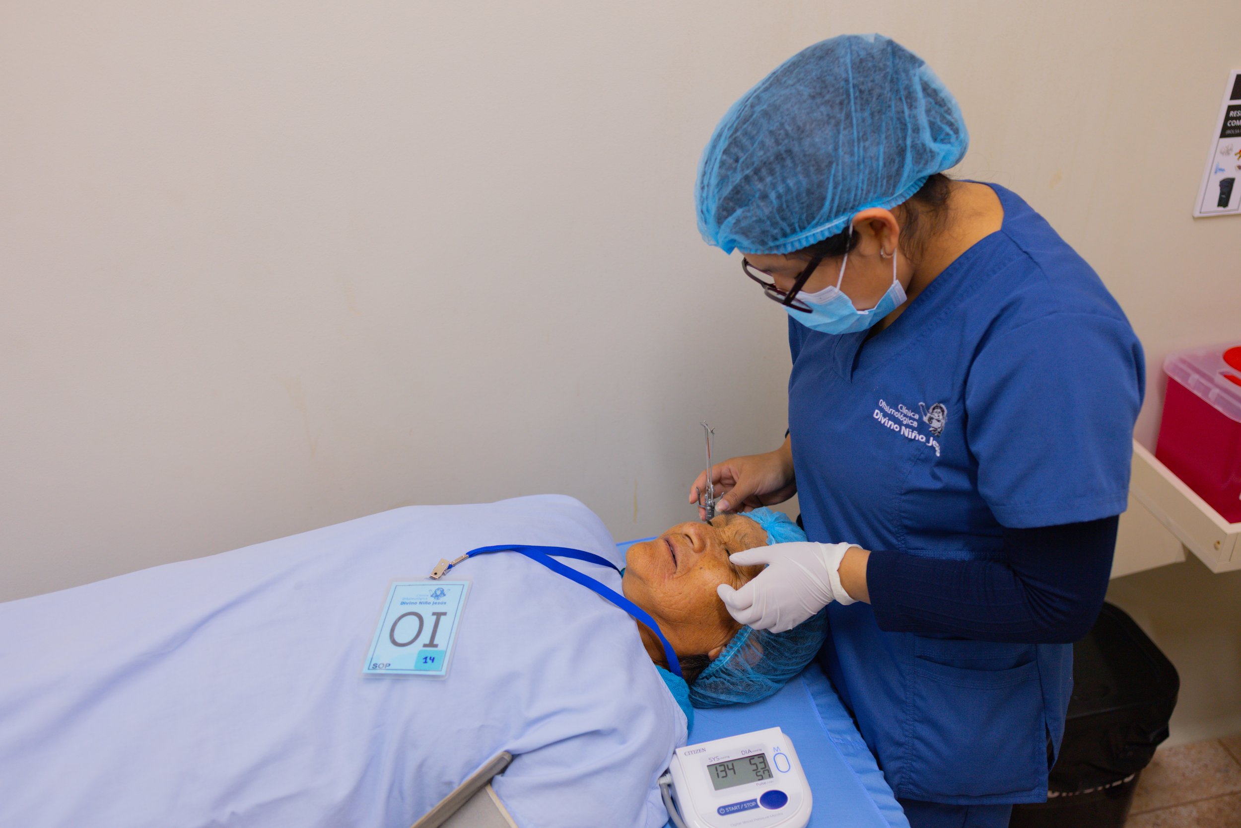 A clinician caring for a woman lying on a hospital bed