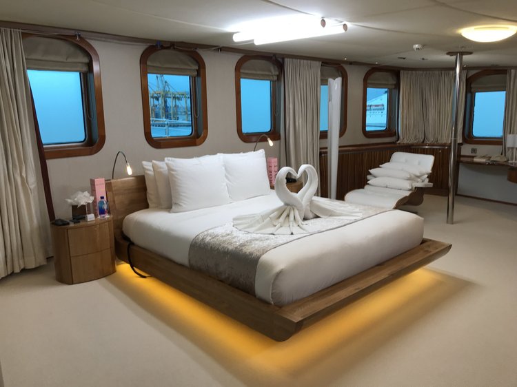 Yacht stateroom with a floating bed lit by warm under-bed LED, installed by The Camera EYE