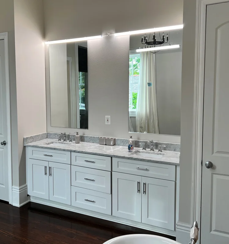 Primary bathroom with backlit mirror lighting and a double vanity in the Real World New Orleans house