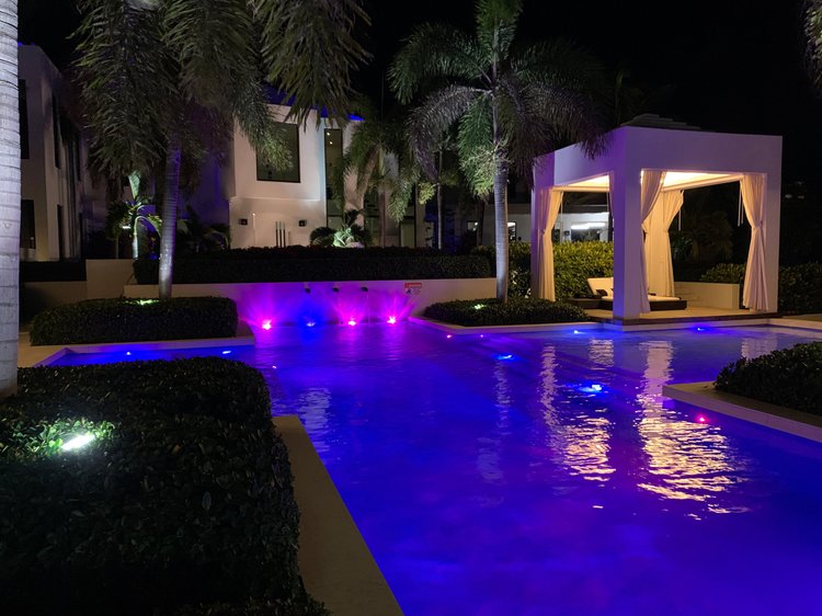 Resort-style pool and cabana at night lit with colour-changing LED at the Turks & Caicos villa
