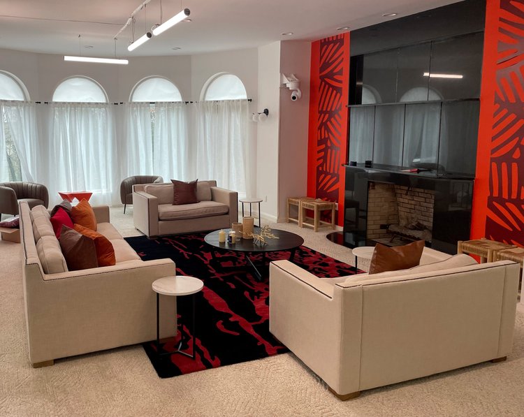 Living room with a red graphic feature wall, fireplace and suspended LED lighting in the Black Ink New York (East Hills) house