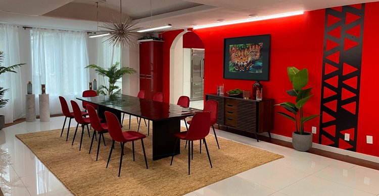 Dining room with a red mural feature wall and automated cove lighting in the Black Ink New York (East Hills) house