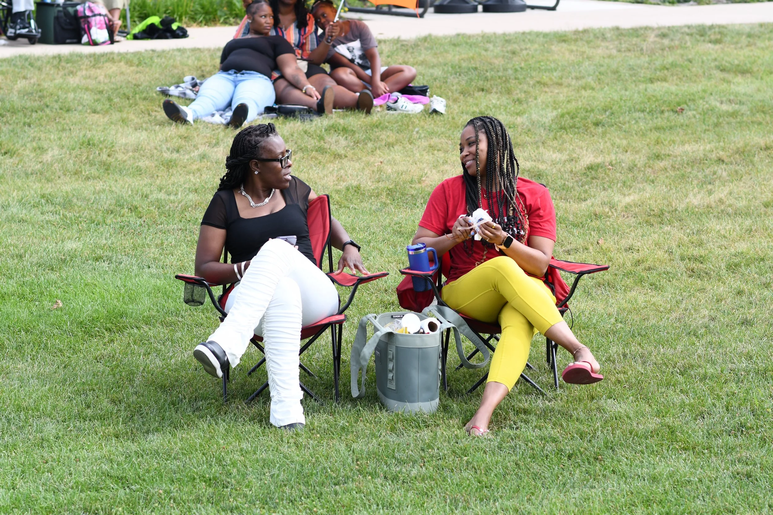 Two friends talking together in lawn chairs at Fort Ben