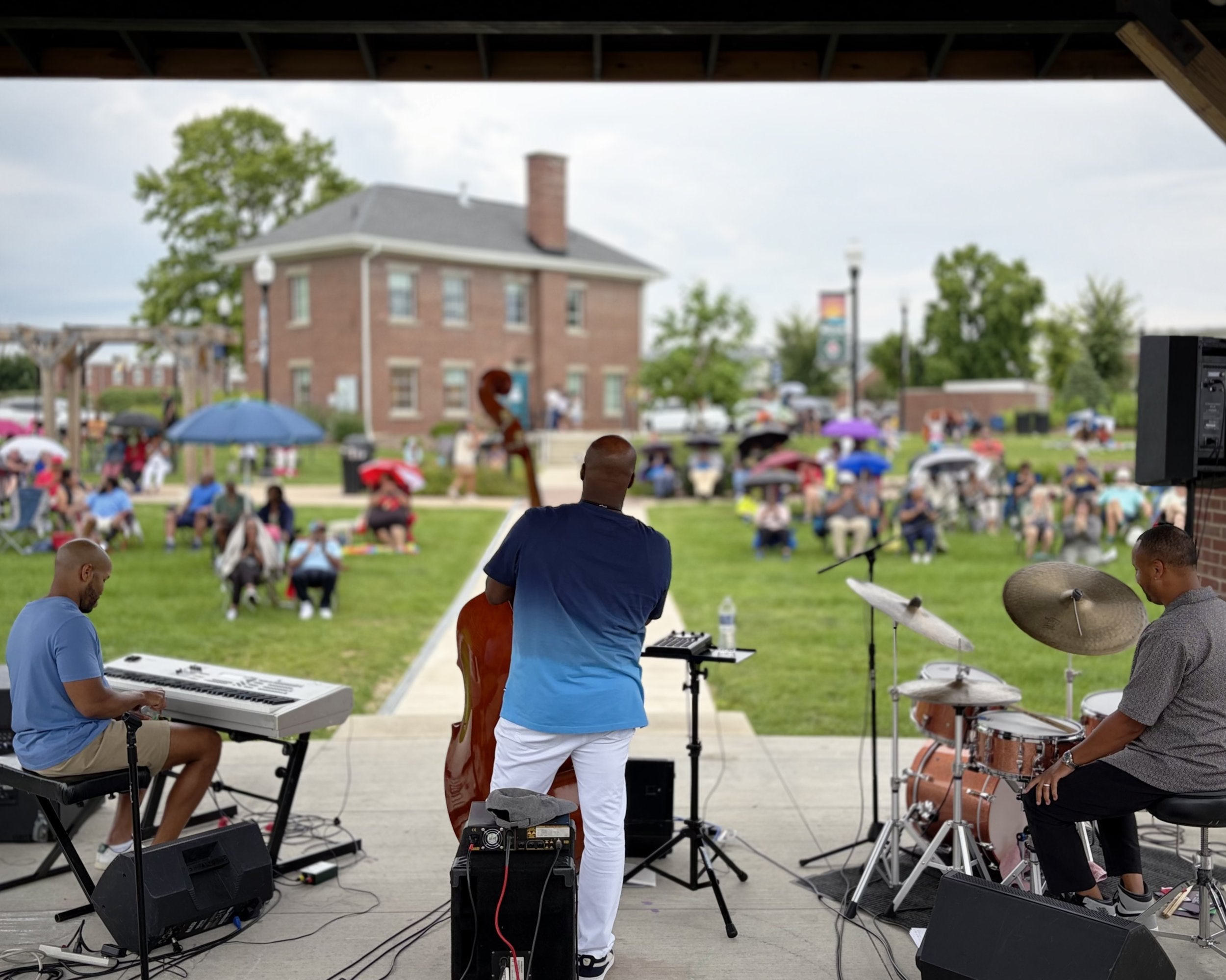 Musicians performing for an audience gathered on the lawn at Fort Ben Cultural Campus