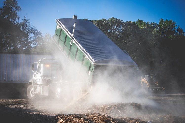 Dump truck tipping a load of yard and wood waste at the Soil Dynamics drop-off yard