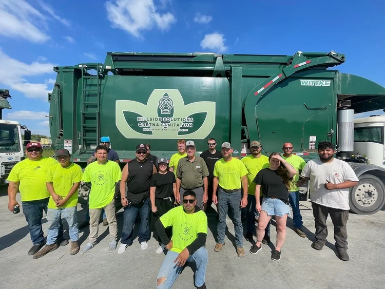 The Gretna Sanitation and Hillside Solutions crew in front of a green collection truck