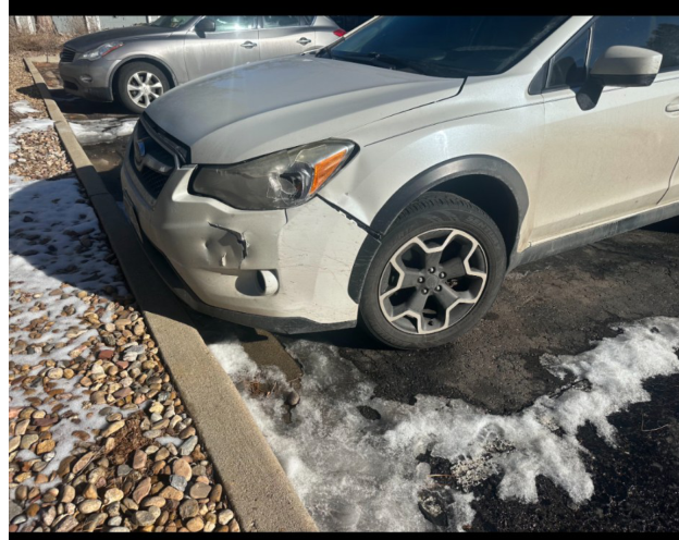 Photograph of the damaged white Subaru.
