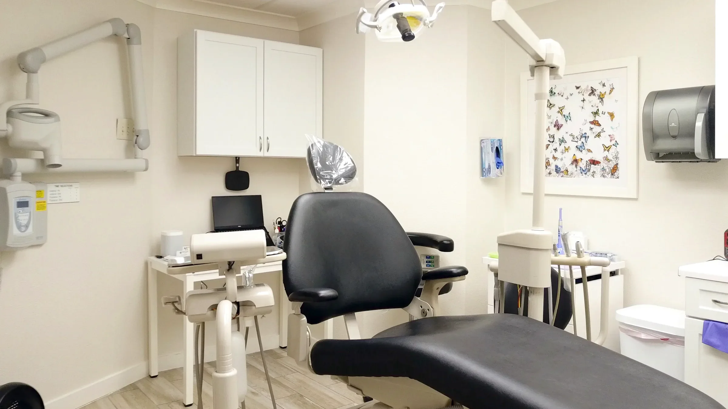 GFID operatory with black dental chair and butterfly wall art